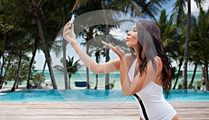 Young woman taking selfie with smartphone