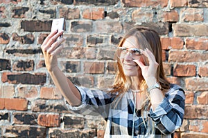 Young woman taking selfie wearing new eyeglasses