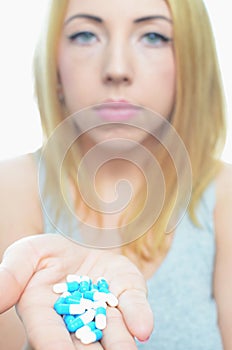 Young woman taking temperature and pills