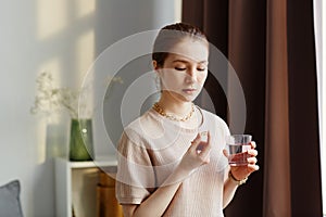 Young Woman Taking Vitamin Supplements