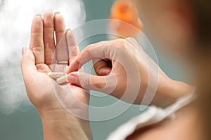 Young woman taking vitamins ginseng pill