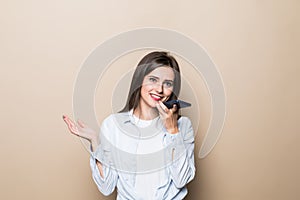 Young woman talk phone loudspeaker isolated on beige background