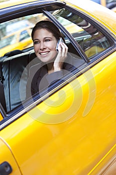 Young Woman Talking on Cell Phone in Yellow Taxi