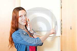 Young woman talking on the house videophone indoor photo