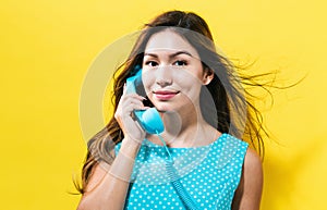 Young woman talking on old fashion phone