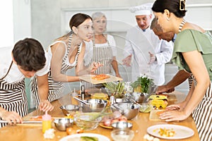 Young woman talking with participants at group culinary class