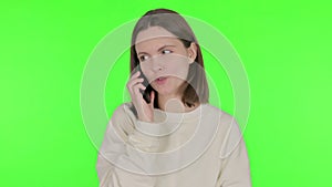 Young Woman Talking on Phone on Green Background