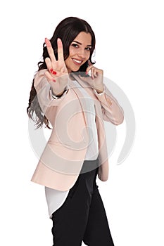 Young woman talking on the phone makes victory sign