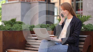 Young Woman Talking on Phone, Negotiating in Good Mood