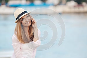 Young woman talking on phone during tropical beach vacation