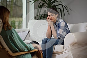 Young woman talking with psychologist photo