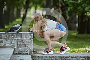 Young woman with tamed crow outdoor