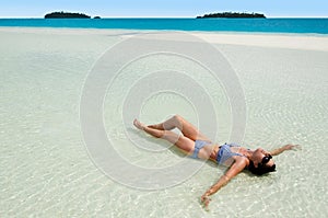 Young woman tanning on Aitutaki Lagoon Cook Islands