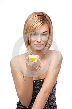 Young woman tasting a lemon