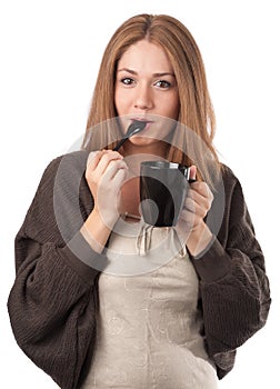 Young woman tasting from a teaspoon