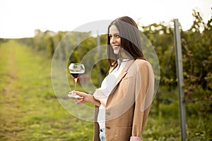 Young woman tasting wine in the vineyard