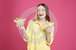 Young woman with tasty sandwiches on background