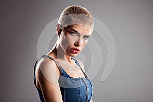 Young woman with tattoos arm and short hair in studio