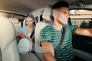 Young woman and taxi driver in modern car