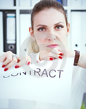 Angry woman tears agreement documents in front of camera closeup.