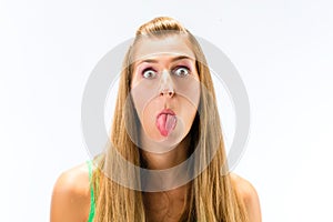 Young woman teasing with sticking her tongue out