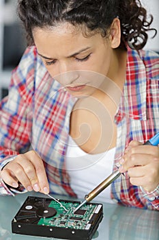 Young woman technician repair electronics device toned image