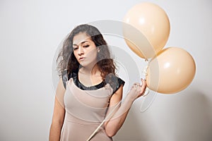 Young woman or teen girl in brown dress with helium air balloons