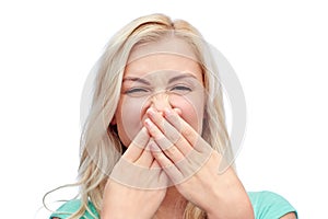 Young woman or teenage girl closing her nose