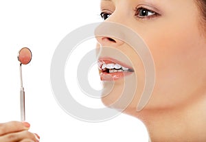 Young woman teeth and a dentist mouth mirror