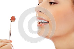 Young woman teeth and a dentist mouth mirror