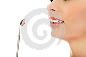 Young woman teeth and a dentist mouth mirror