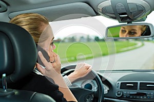 Young woman with telephone in car
