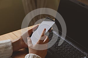 Young woman teleworking at home, checking the smartphone, Spain