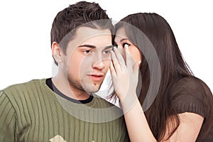 Young woman telling a secret to man