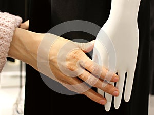 Young woman tenderly touching mannequin. Female hand with mannequin`s hands