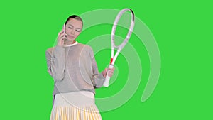 Young woman tennis player talking on the mobile phone on a Green Screen, Chroma Key.