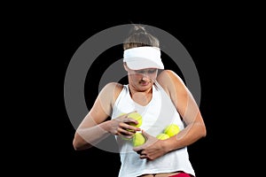 Young woman on a tennis practice. Beginner player holding a racket, learning basic skills. Portrait on black background.