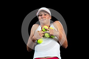 Young woman on a tennis practice. Beginner player holding a racket, learning basic skills. Portrait on black background. photo