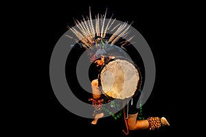 young woman Teotihuacana, Xicalanca - Toltec in black background, with traditional dress dance with a trappings with feathers and photo