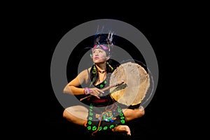 young woman Teotihuacana, Xicalanca - Toltec in black background, with traditional dress dance with a trappings with feathers and photo