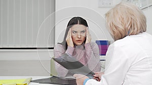 Young woman with terrible headache visiting doctor