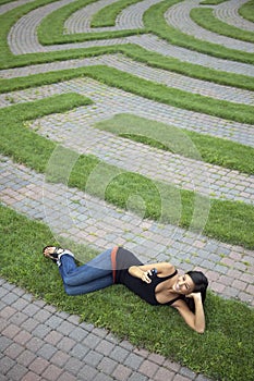 Young Woman Text Messaging in a Grass Maze