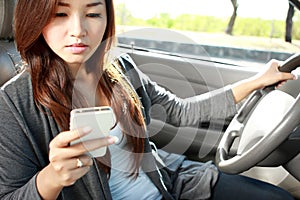 Young woman texting while driving a car