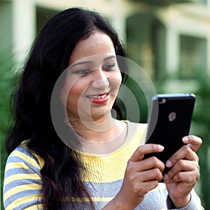 Young woman texting with her cellphone at outdoo