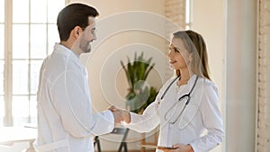 Young woman therapist welcoming new teammate in clinic office