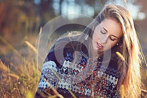 Young woman thinking in autumn meadow