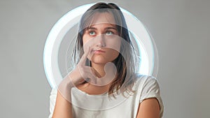 Young woman thinking of something and playing with hair