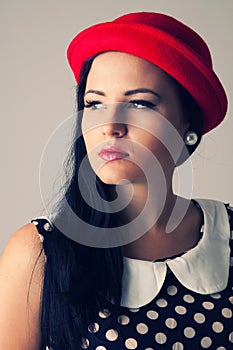 Young woman with thoughtful look in red hat