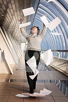 Young woman throwing documents