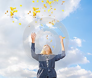 Young woman throwing leaves in the air